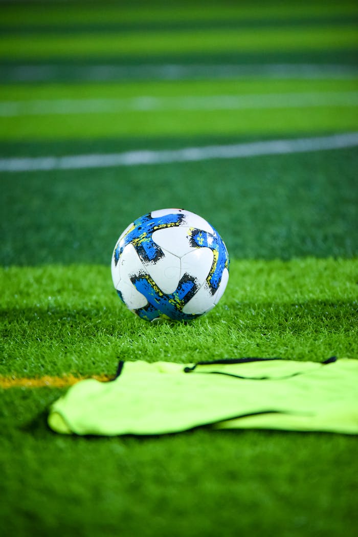 Vibrant soccer field scene featuring a ball and training gear on well-maintained turf.